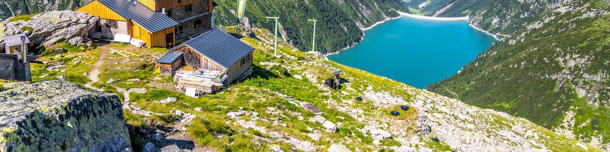 A mountain house with a lake in the valley below.