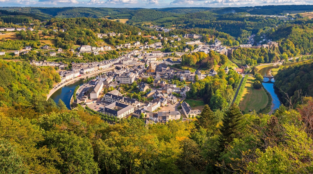 A town nestled in a valley with a river, surrounded by forested hills.