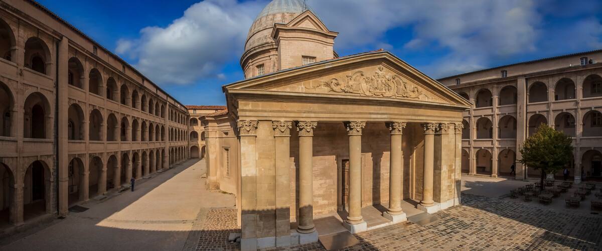 Panorama with the classical chapel and arcaded galleries in the courtyard of the cultural center of historic hospital Centre de la Vieille Charité or Center of the Old Charity in Marseille, France