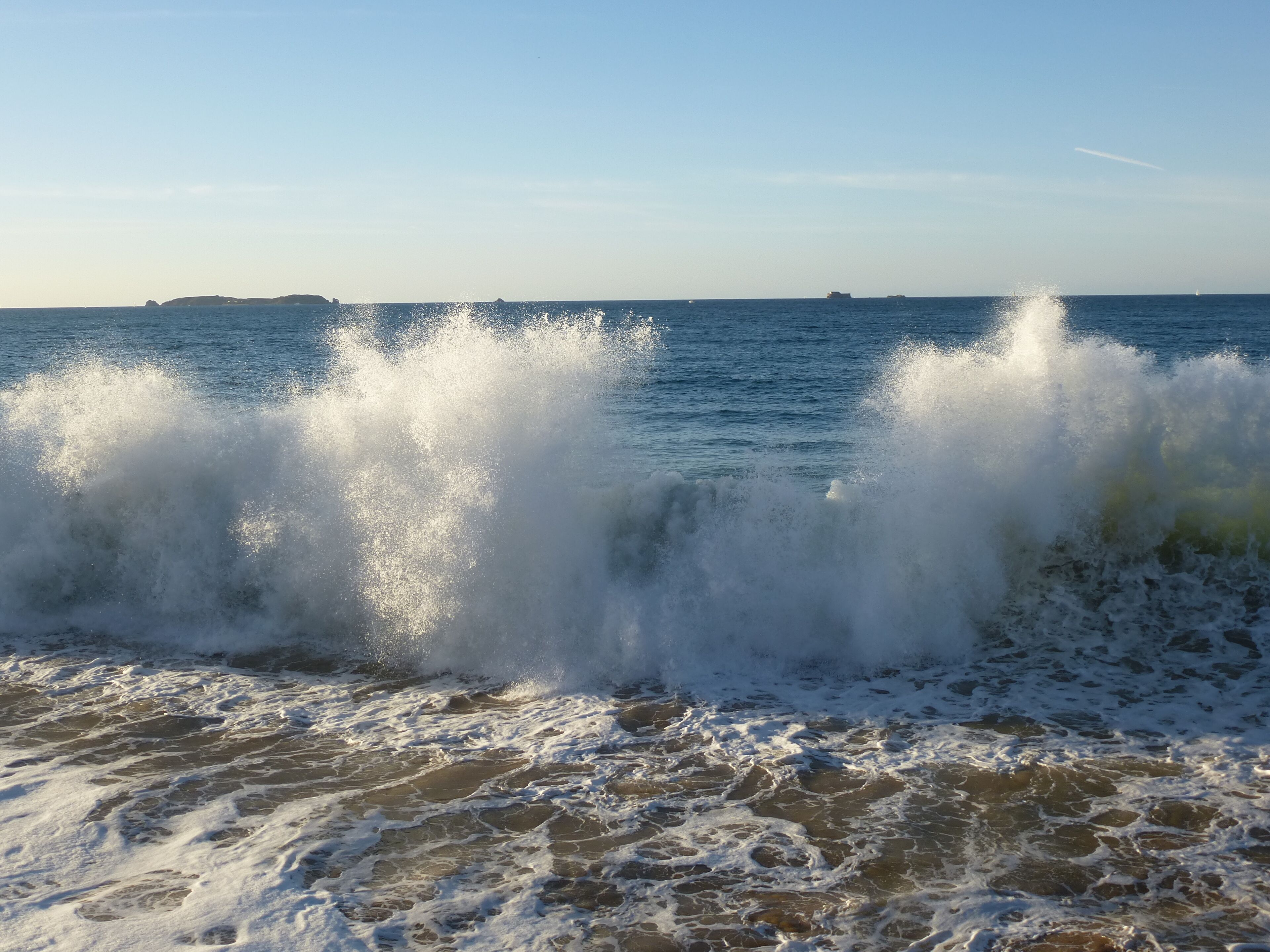 A beach with waves crashing onto the shore.