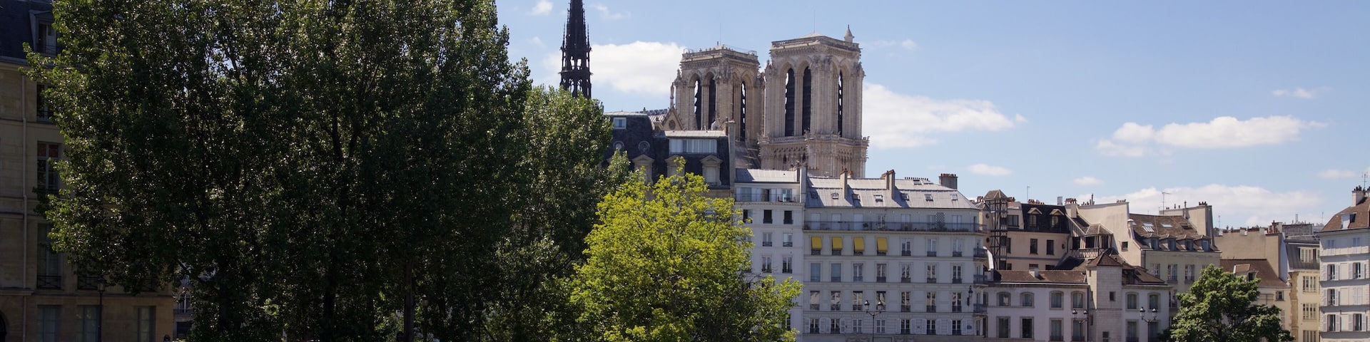 View of the River Seine from the Louis Phillip Bridge with the Ăle Saint-Louis (in the foreground) and the the Ăle de la CitĂ© (with the towers of Notre Dame). It was a warm July day so there were several folks hiding in the shade beside the river.