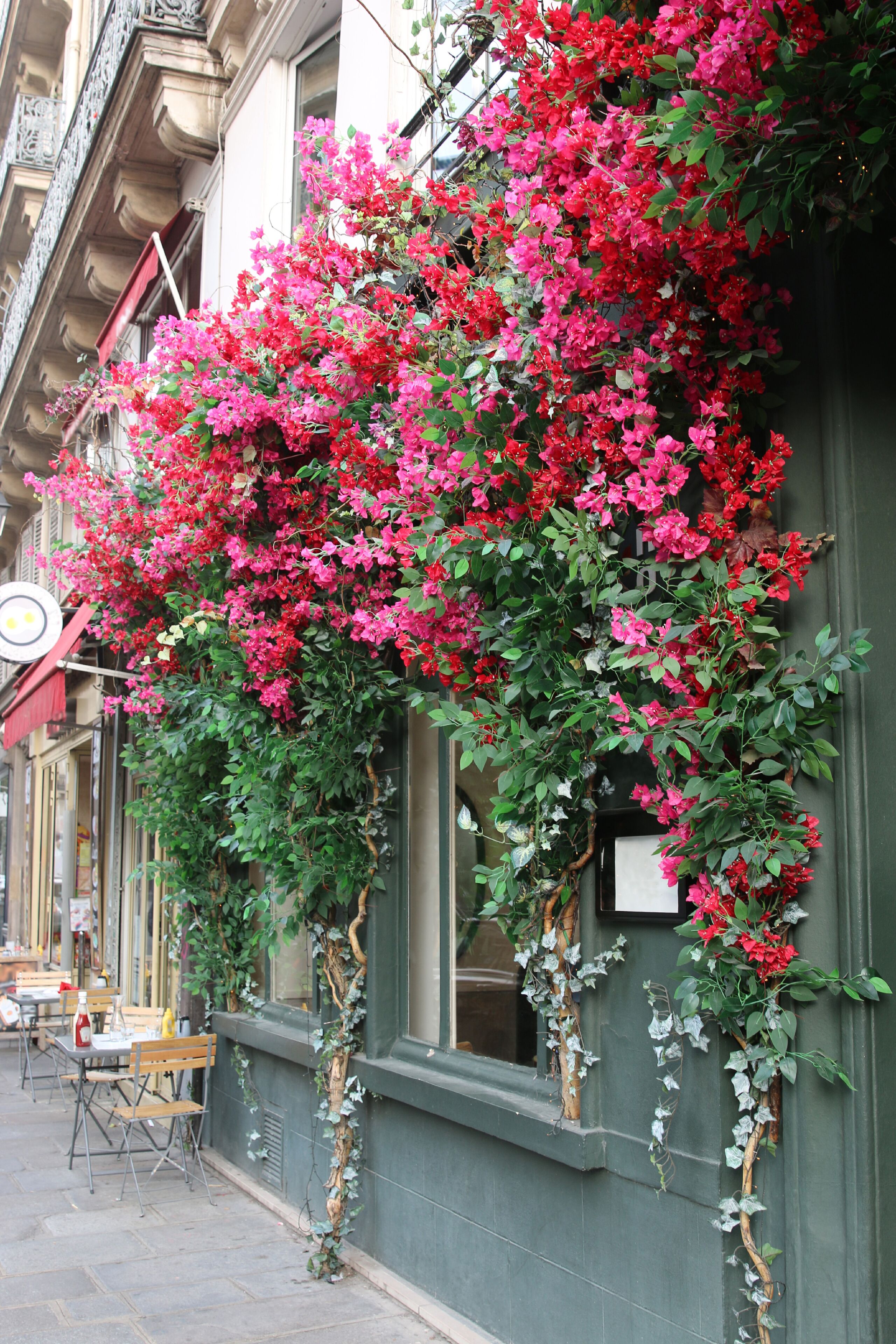 Un edificio con fiori di bougainvillea rosa intenso che ricoprono la parete esterna.