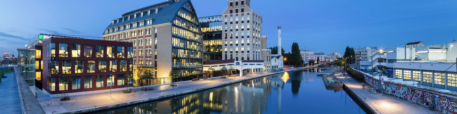 Pantin Mills, and canal of Ourcq, in Pantin, Seine-Saint-Denis, France. Renovated in the years 2000s, Pantin Mills now serve as offices and headquarters for BNP Paribas Securities Services. This picture is a mosaic of 13 pictures each taken at 21mm, f/8.0, 3.5 sec and ISO 100, with a Canon 7D + Canon 17-55 f/2.8 mounted on. Stitching itself was done with Hugin. Resulting horizontal FOV is 164°.