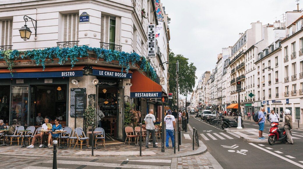 Eine Straße mit Cafés und Restaurants, darunter 'BISTRO' und 'LE CHAT BOSSU'.