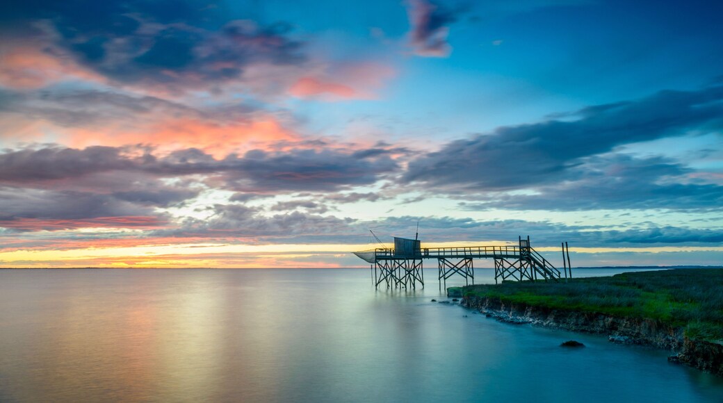 Sunset on Atlantic coast of Charente Maritime, France with traditional fishing hut and calm seas near La Rochelle
