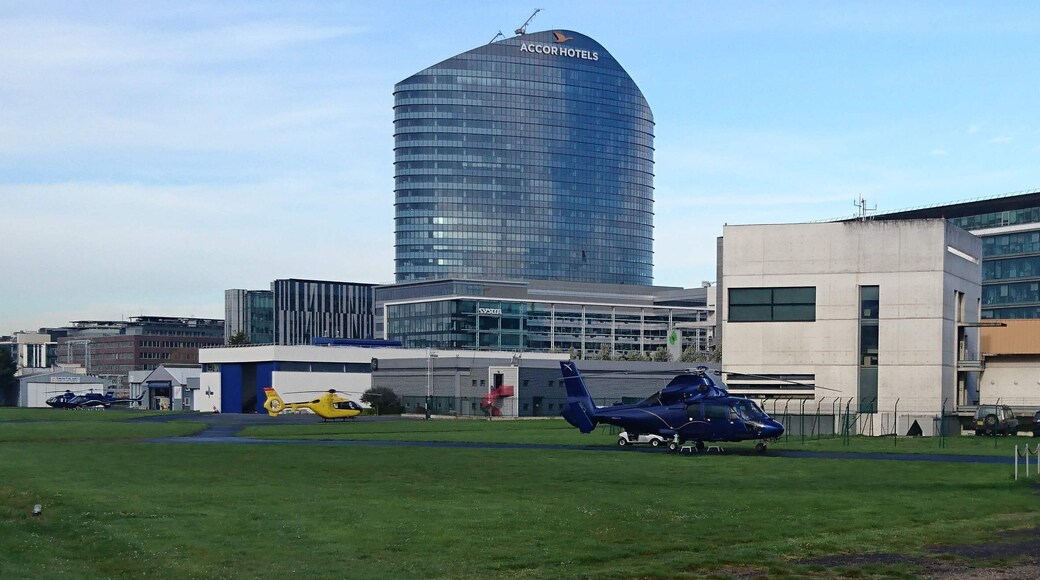 Héliport d'Issy les Moulineaux. L'hélicoptère bleu est immatriculé F-HUGO. C'est un SA 365 N construit par Eurocopter. Son propriétaire est GO FAST TRANSPORT. En arrière plan, Accor hotel et la DGAC.