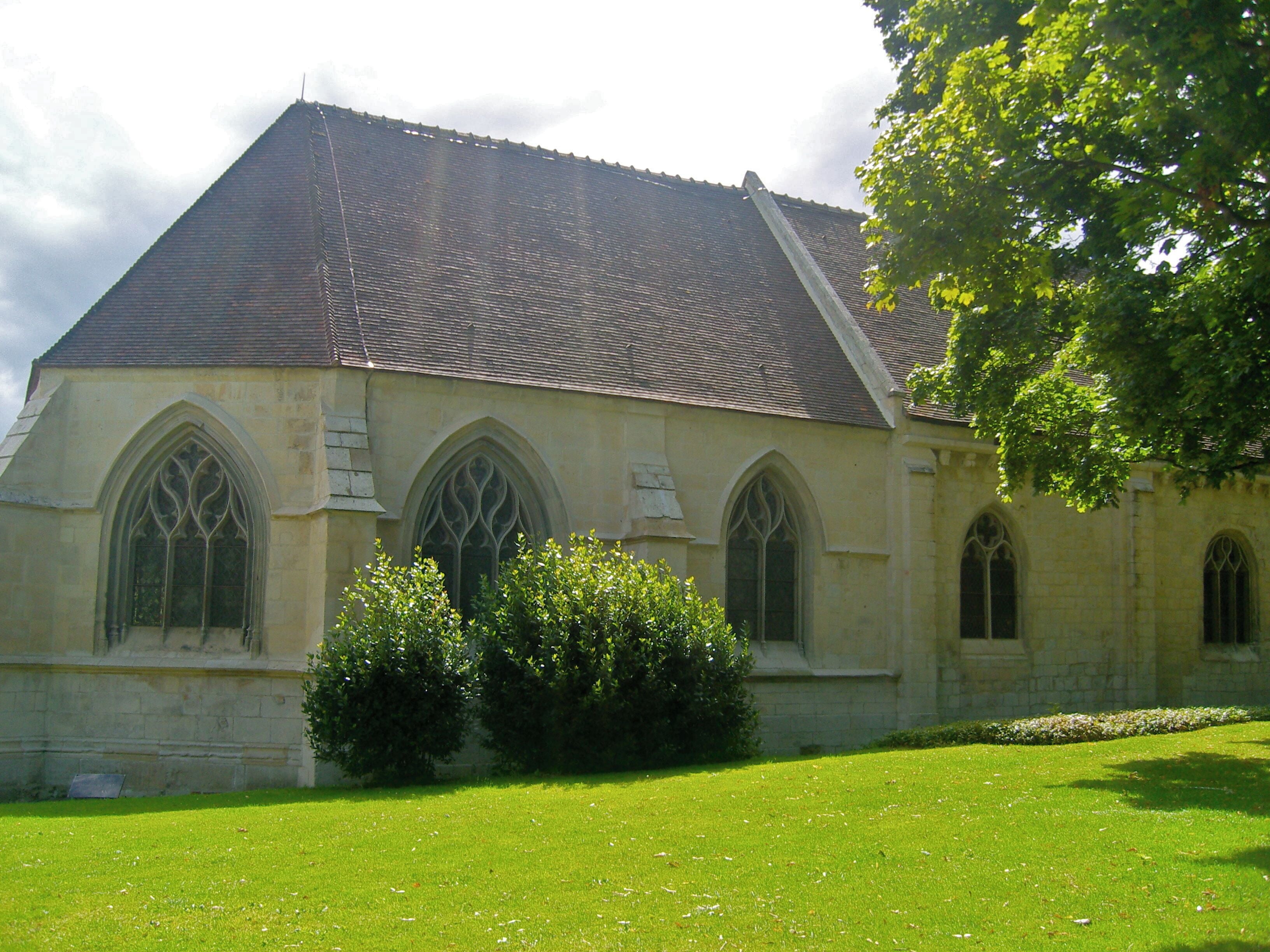 A church with a steeply pitched roof, pointed arch windows, and a stone facade.