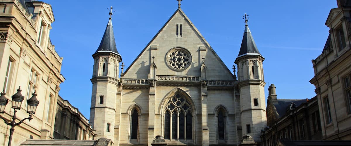 Eine historische Kirche mit einem großen Rosenfenster, zwei Türmen und einem eingenetzten Eingang.