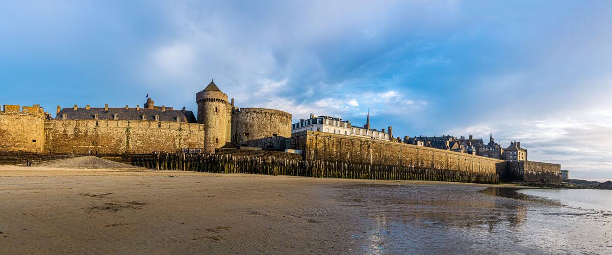 Saint Malo cityscape or skyline at dusk. Medieval ramparts surrounding the historic town from Plage de l'Eventail panoramic scenery, Brittany, France.