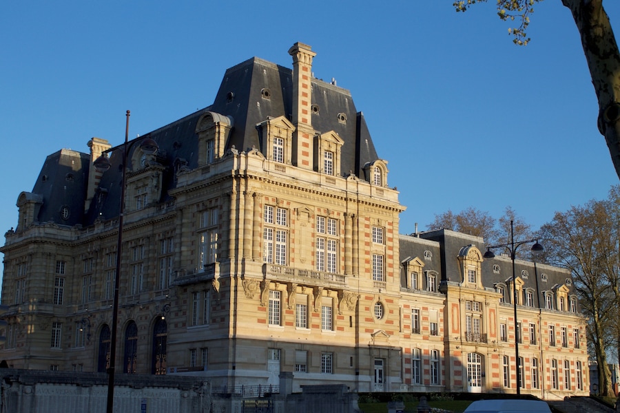 A large, historic building with multiple towers and arched windows.