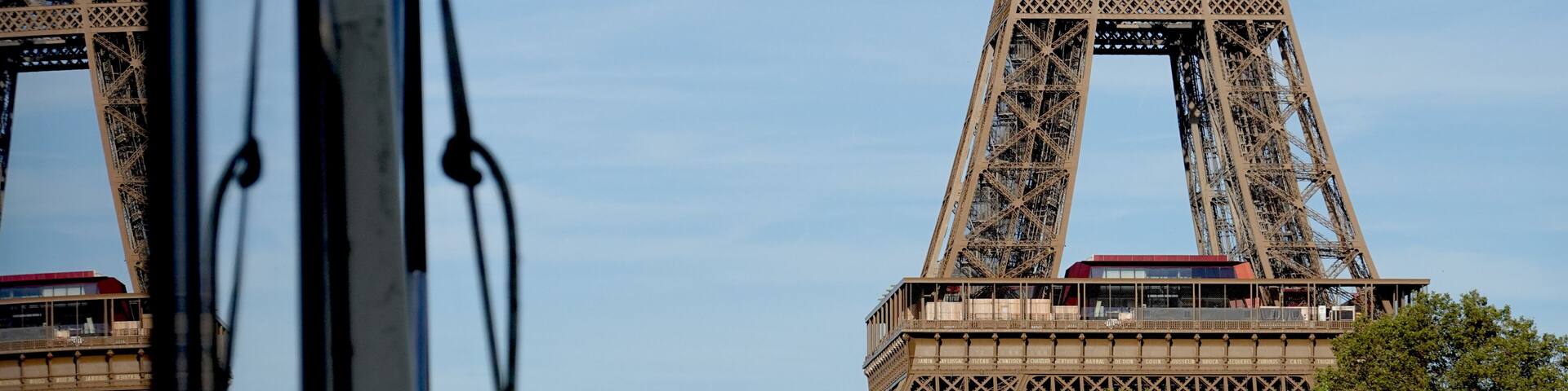 The Eiffel Tower, a bridge with a statue, and a red train on the bridge.
