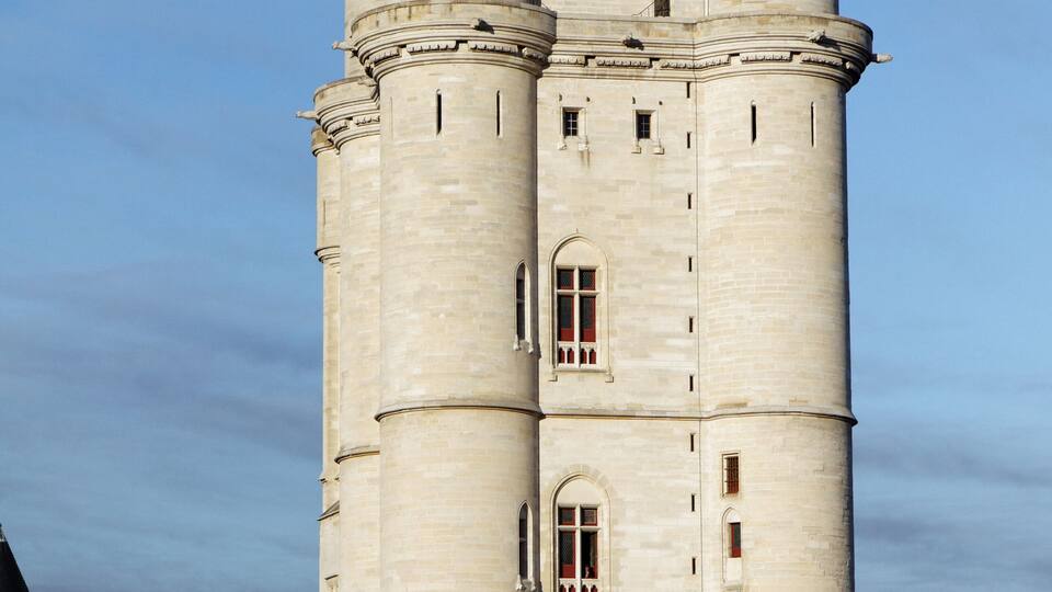 A large, historic tower with multiple levels and a flag on top.