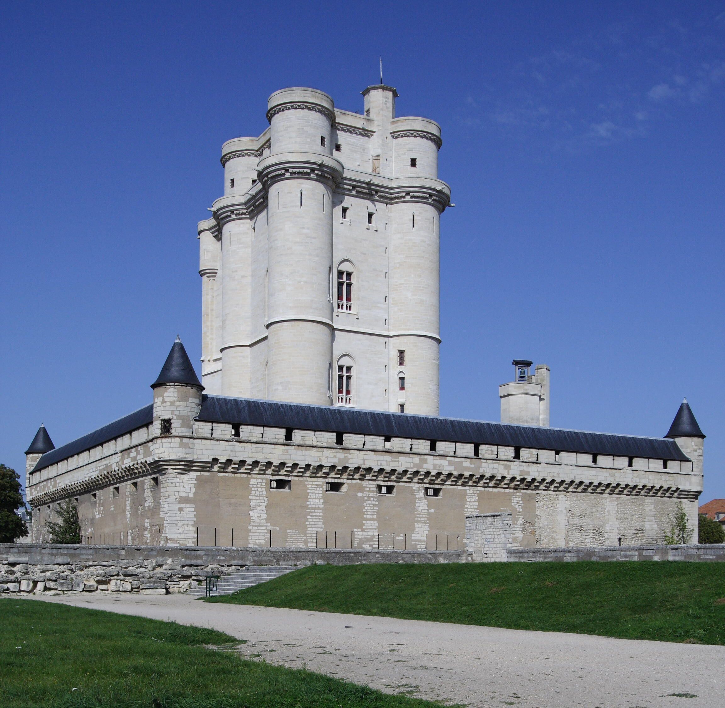 Un vaste château historique doté de nombreuses tours et d’une tour centrale imposante.