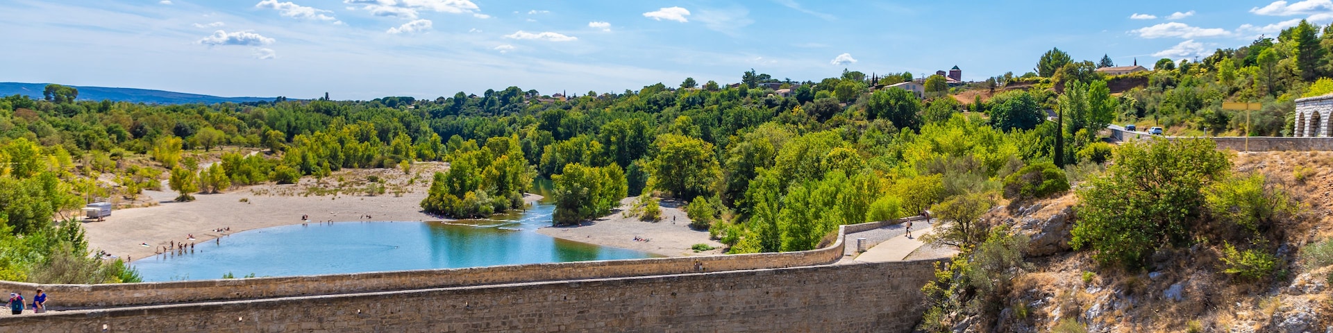 A stone bridge over a river with a clear blue sky.