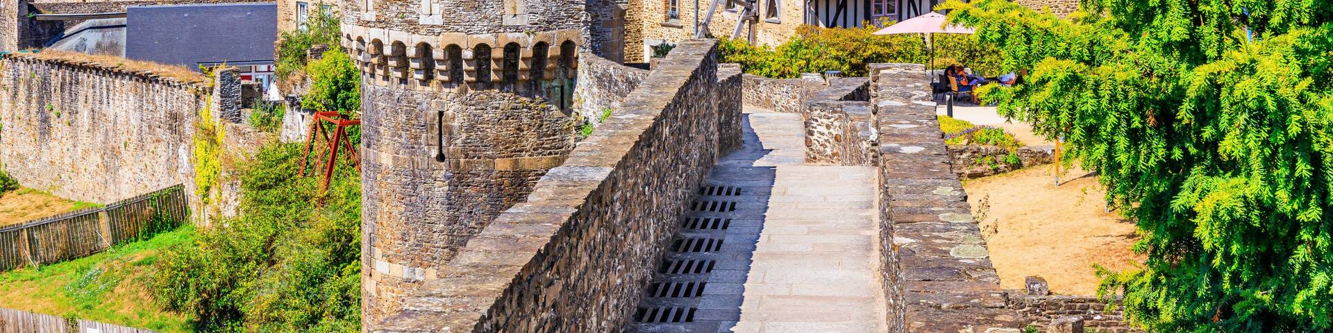 A historic town with medieval architecture, including stone towers and a fortified wall.