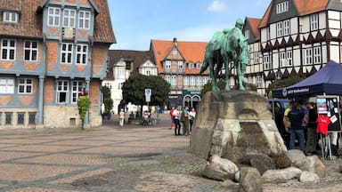 Una plaza adoquinada con edificios tradicionales de entramado de madera, una estatua de un caballo y una carpa con el rótulo 'MTV Wolfenbüttel'.