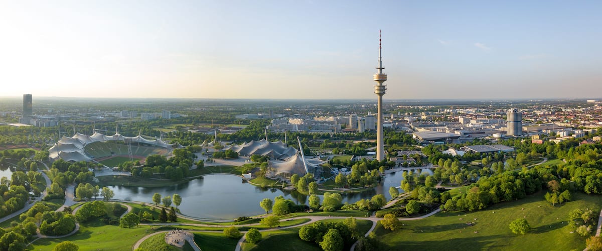 Ein Stadtbild mit einem markanten Turm, einem See und markanter moderner Architektur.