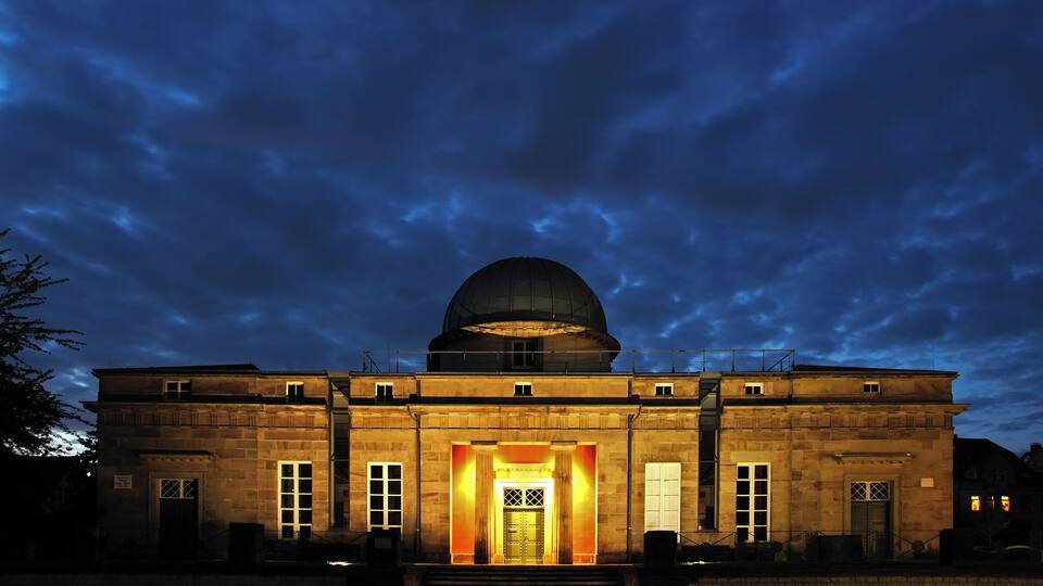 A historic building with a large dome and a well-lit entrance.