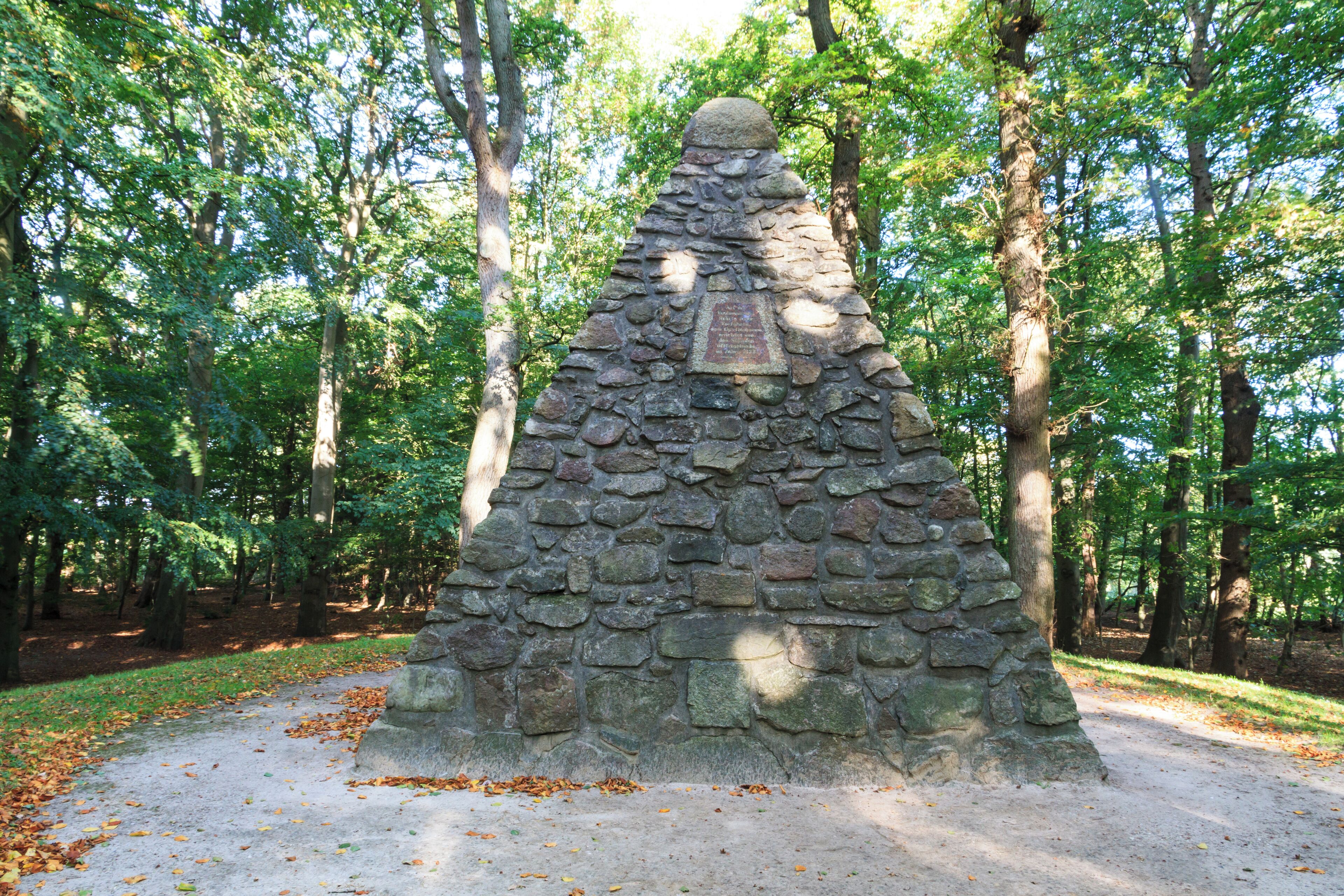 A stone monument surrounded by trees.