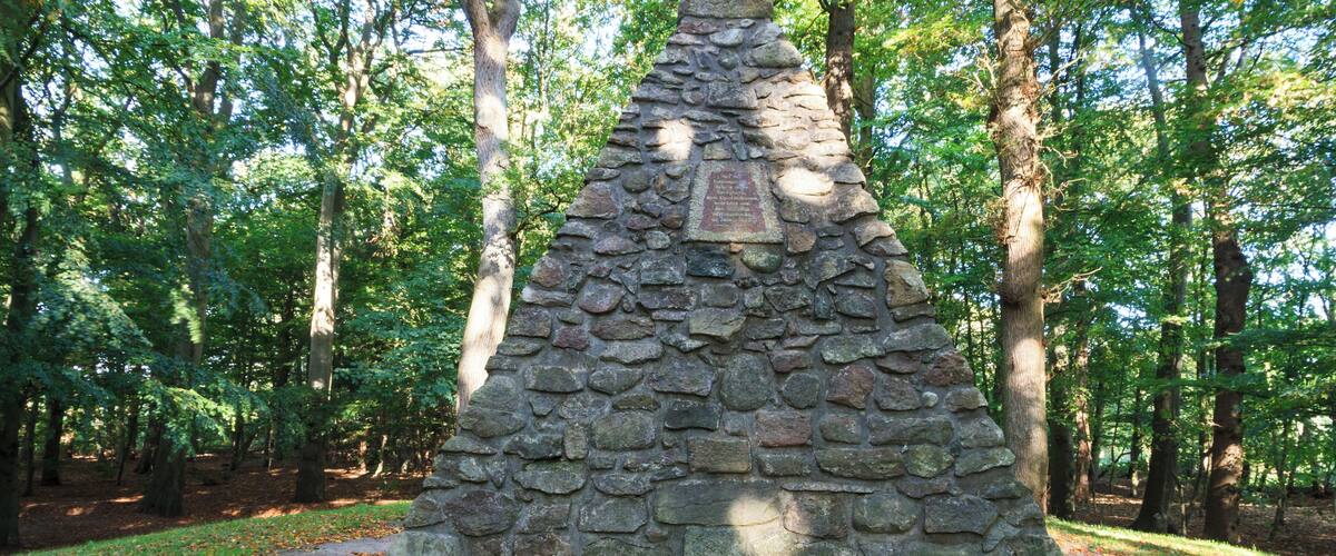 A stone monument surrounded by trees.