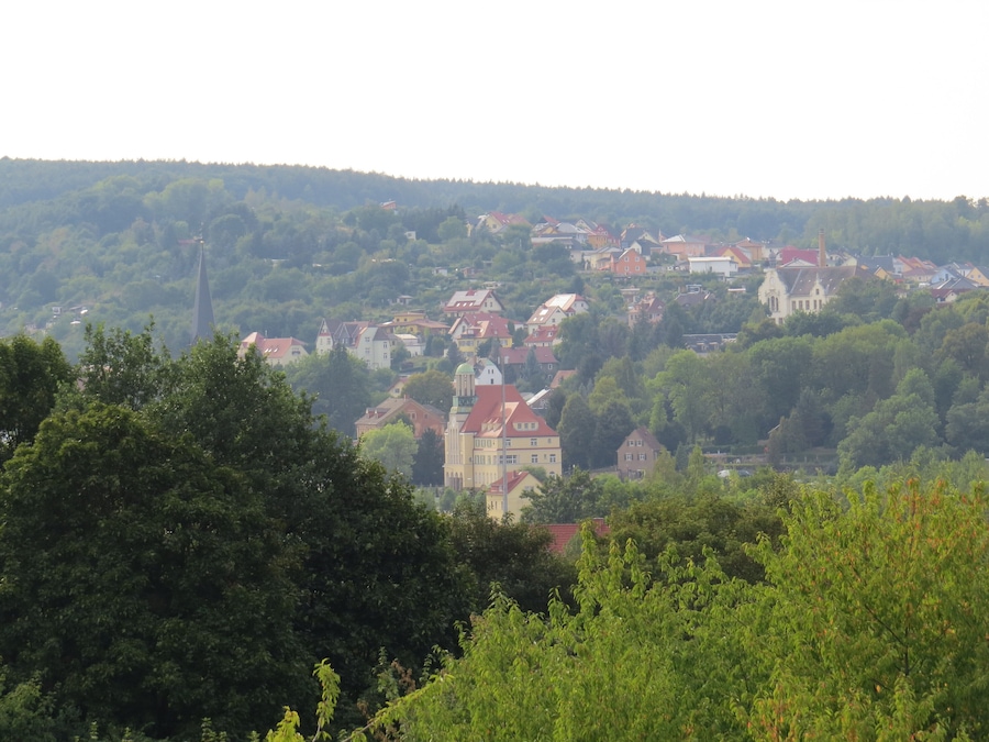 A town nestled in a valley with red-roofed houses and a prominent church.