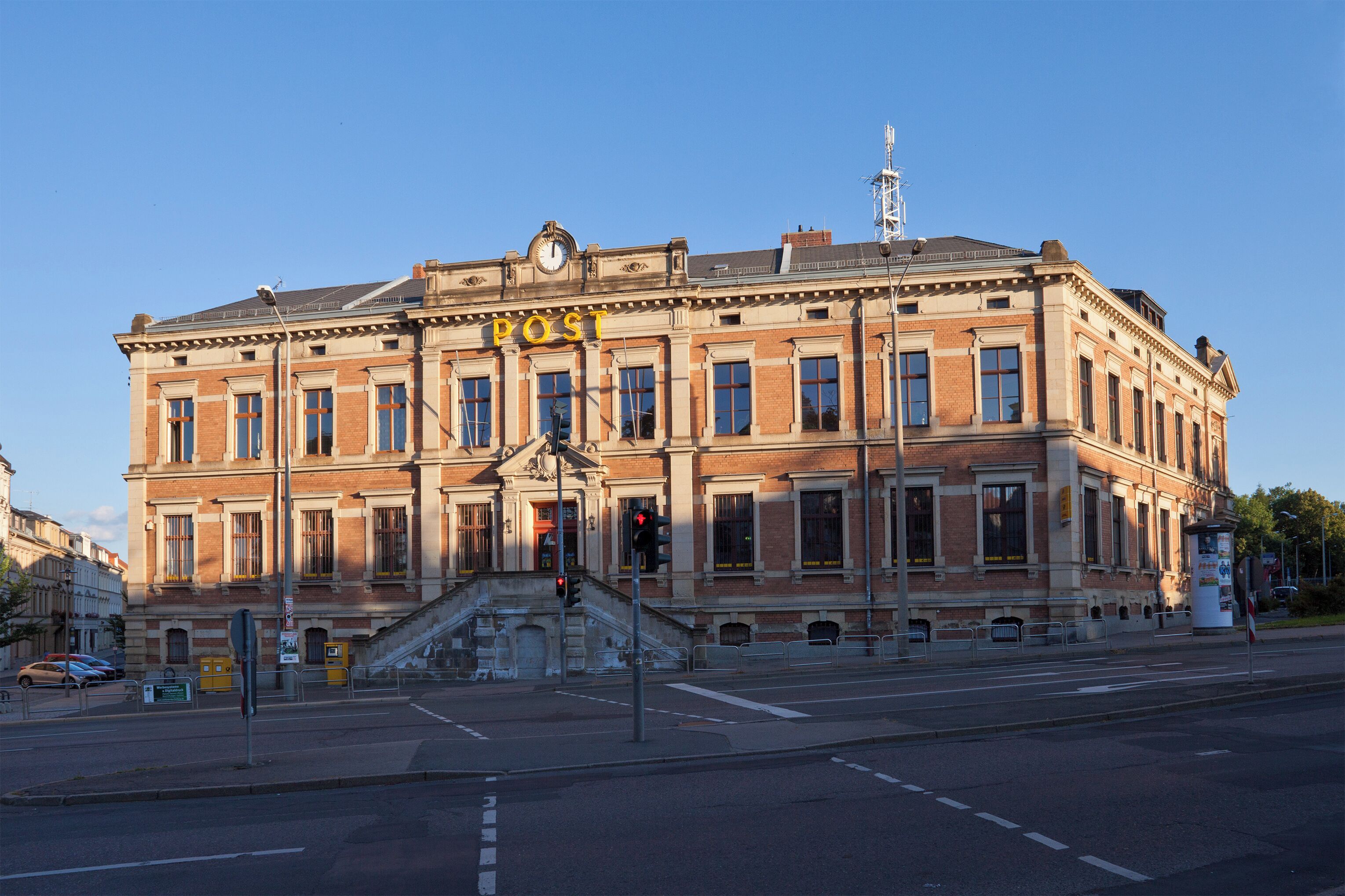 A historic building with a prominent 'POST' sign, large windows, and a clock tower.