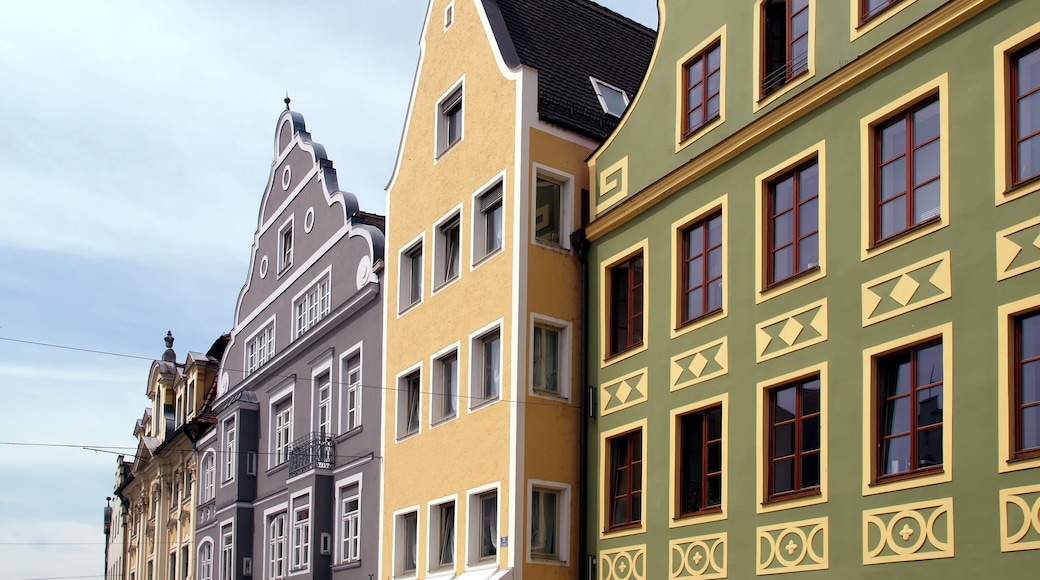 A row of colorful buildings with distinct architectural styles, including a building with a pointed roof and another with decorative window frames.