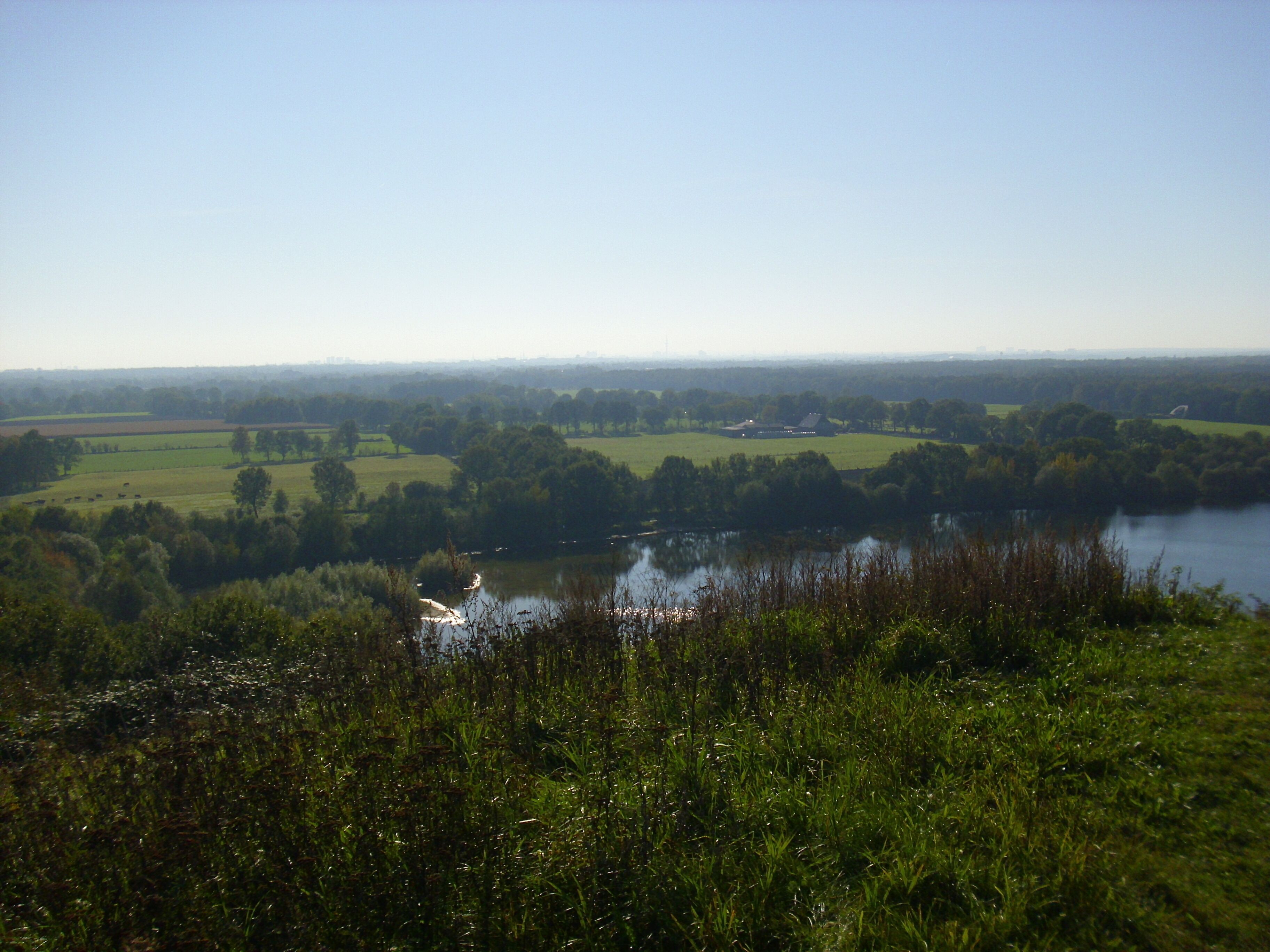 Blick vom Müllberg Hummelsbüttel nach Süden auf den Hummelsee und die Hummelsbütteler Feldmark (Landschaftsschutzgebiet "Hummelsbütteler Feldmark/Alstertal"), im Hintergrund Wohnwirtschaftsgebäude Glashütter Landstraße 182, denkmalgeschützt lt. LdK HH-Hummelsbüttel Nr. 26907.