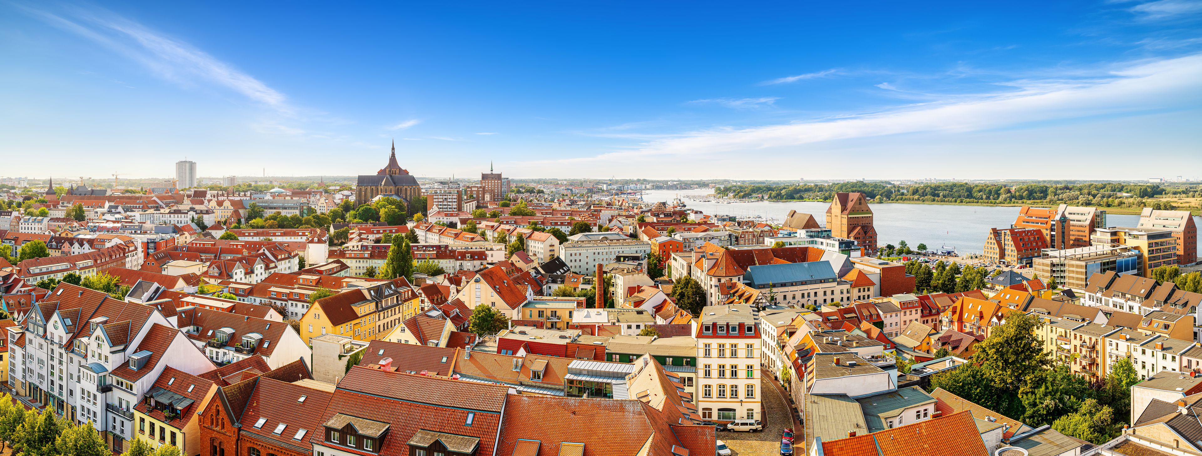 A panoramic view of a city with a river, historic buildings, and a prominent church.