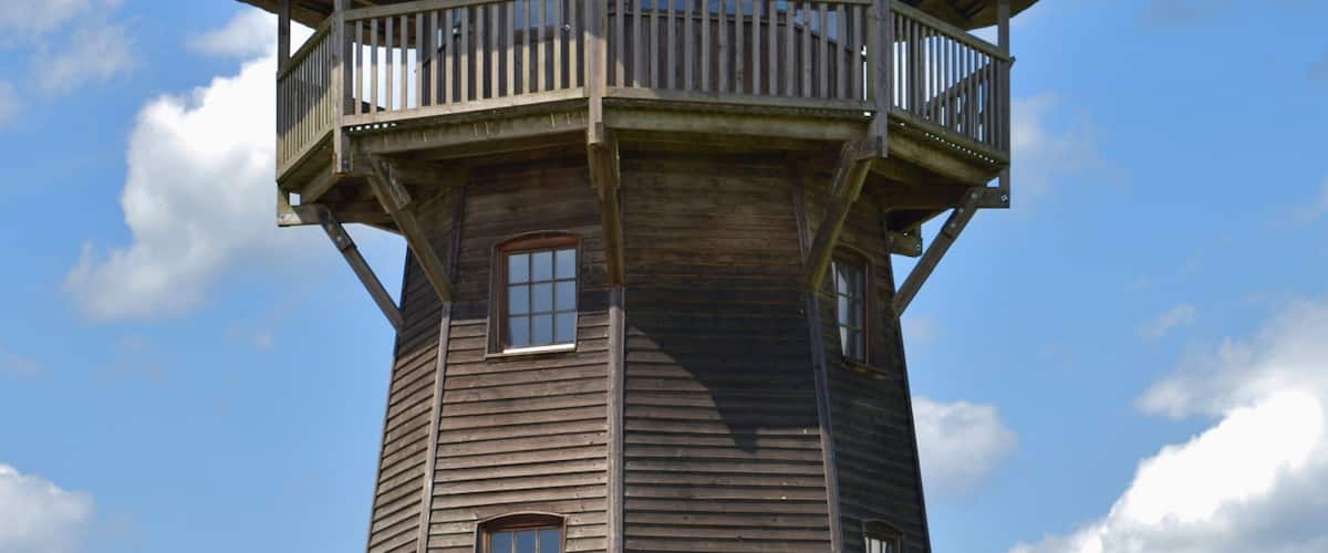 A wooden tower with a thatched roof and a balcony.