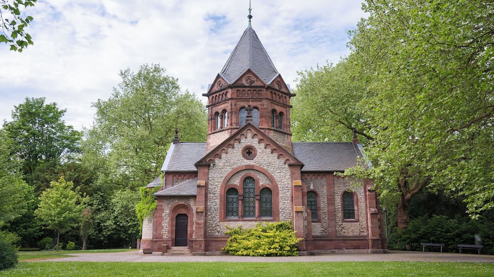 A historic church with a pointed steeple, arched windows, and a brick facade.
