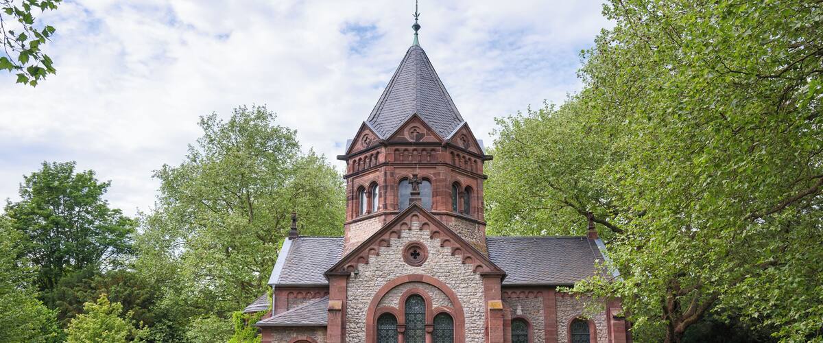 A historic church with a pointed steeple, arched windows, and a brick facade.
