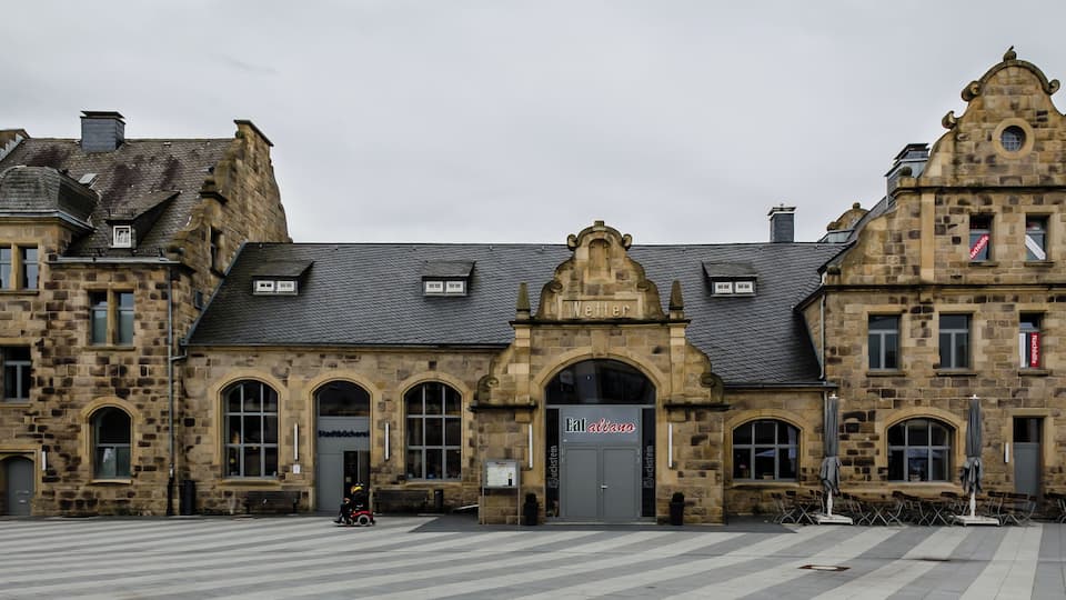 A historic stone building with arched windows and a sign that reads "Stadtbücherei".