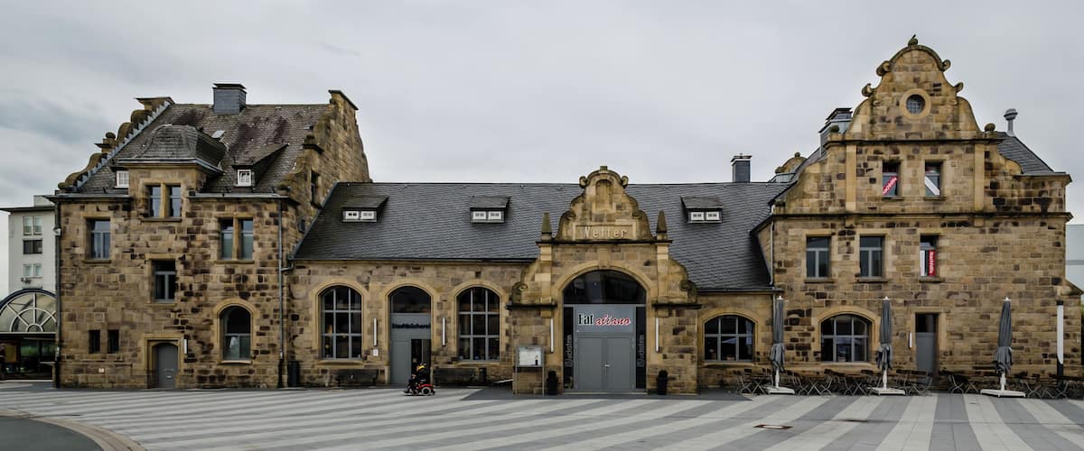 A historic stone building with arched windows and a sign that reads "Stadtbücherei".