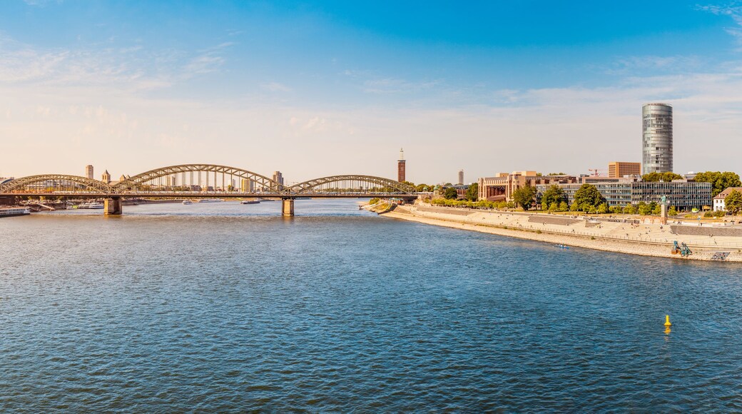 A river with boats, a bridge, and a cathedral.