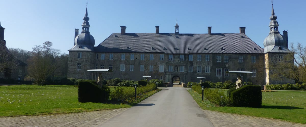 A large stone building with a central entrance and two symmetrical towers.