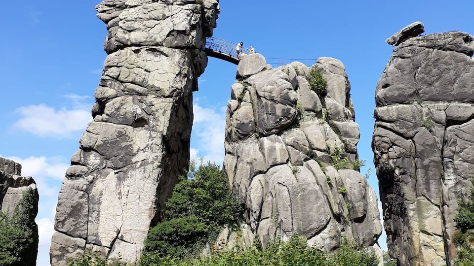 A rocky landscape with a narrow bridge connecting two rock formations.