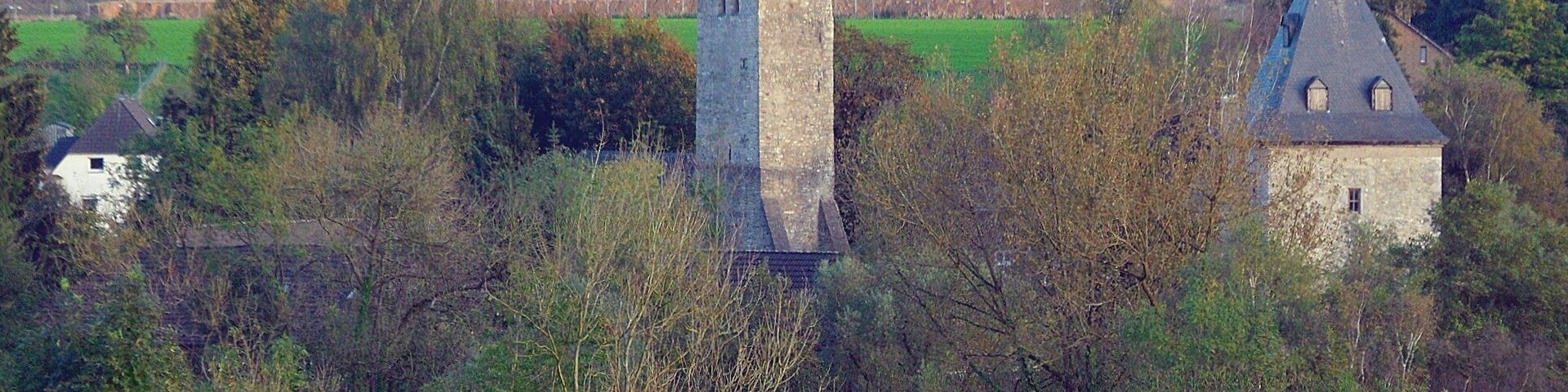 Wuppertal-Schöller: protestant parish church (centre), and defence tower of Gut Schöller (right); in background premises for limestone mining; October 2014