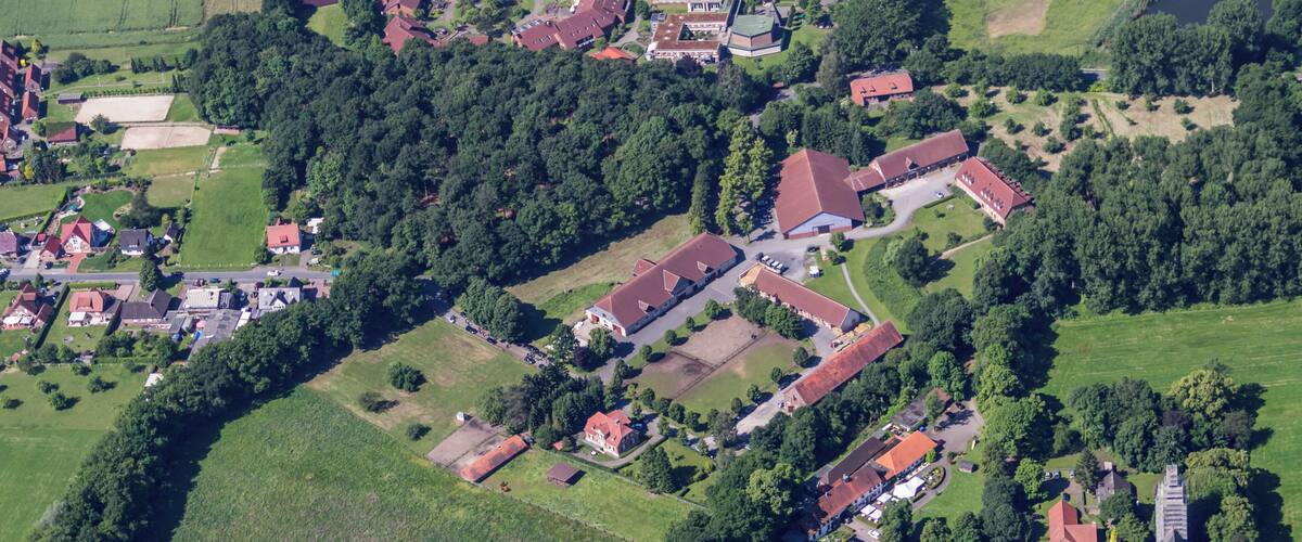 An aerial view of a village with houses, a church, and a river.