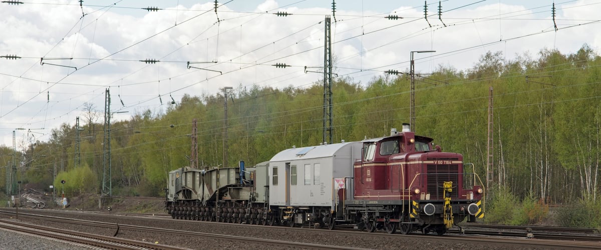 Een bijzondere samenstelling van de DB V60 1184, een verblijfswagen en een trafowagon, rijdt Bochum-Ehrenfeld binnen. Uaai is de naam van de trafowagen, met 20 assen. In totaal zijn 5 exemplaren gebouwd door MAN Tragschnäbeln.