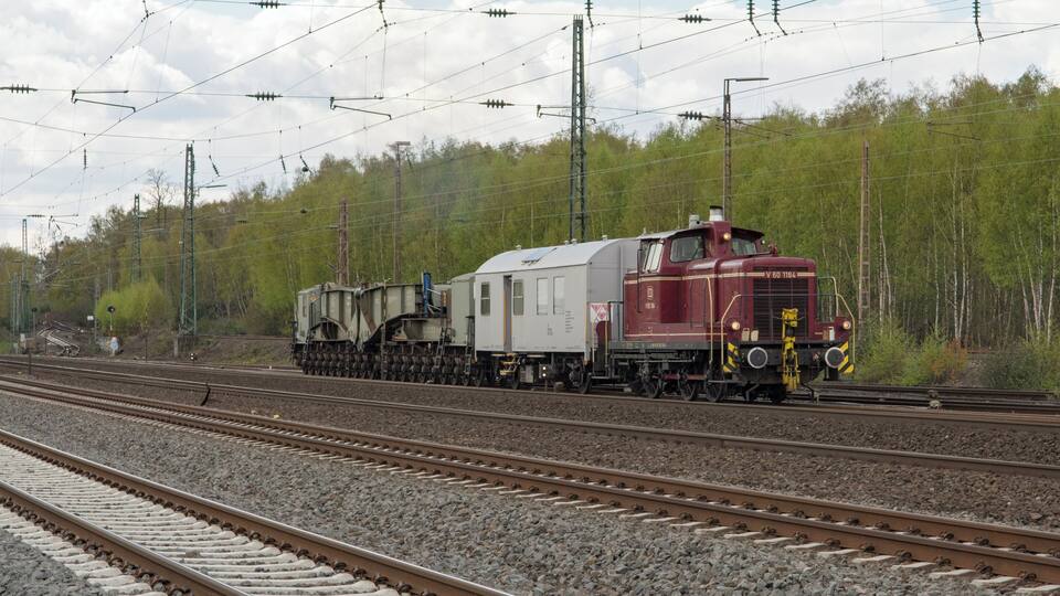 Een bijzondere samenstelling van de DB V60 1184, een verblijfswagen en een trafowagon, rijdt Bochum-Ehrenfeld binnen. Uaai is de naam van de trafowagen, met 20 assen. In totaal zijn 5 exemplaren gebouwd door MAN Tragschnäbeln.