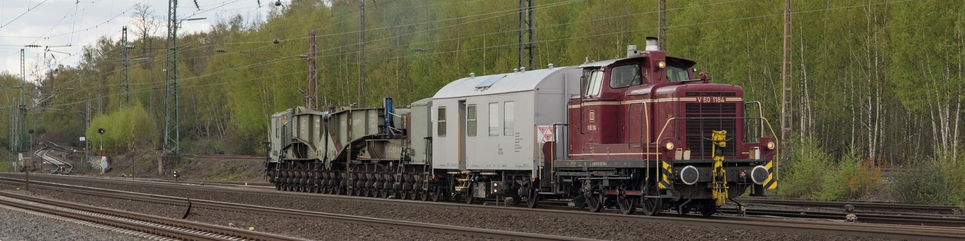 Een bijzondere samenstelling van de DB V60 1184, een verblijfswagen en een trafowagon, rijdt Bochum-Ehrenfeld binnen. Uaai is de naam van de trafowagen, met 20 assen. In totaal zijn 5 exemplaren gebouwd door MAN Tragschnäbeln.