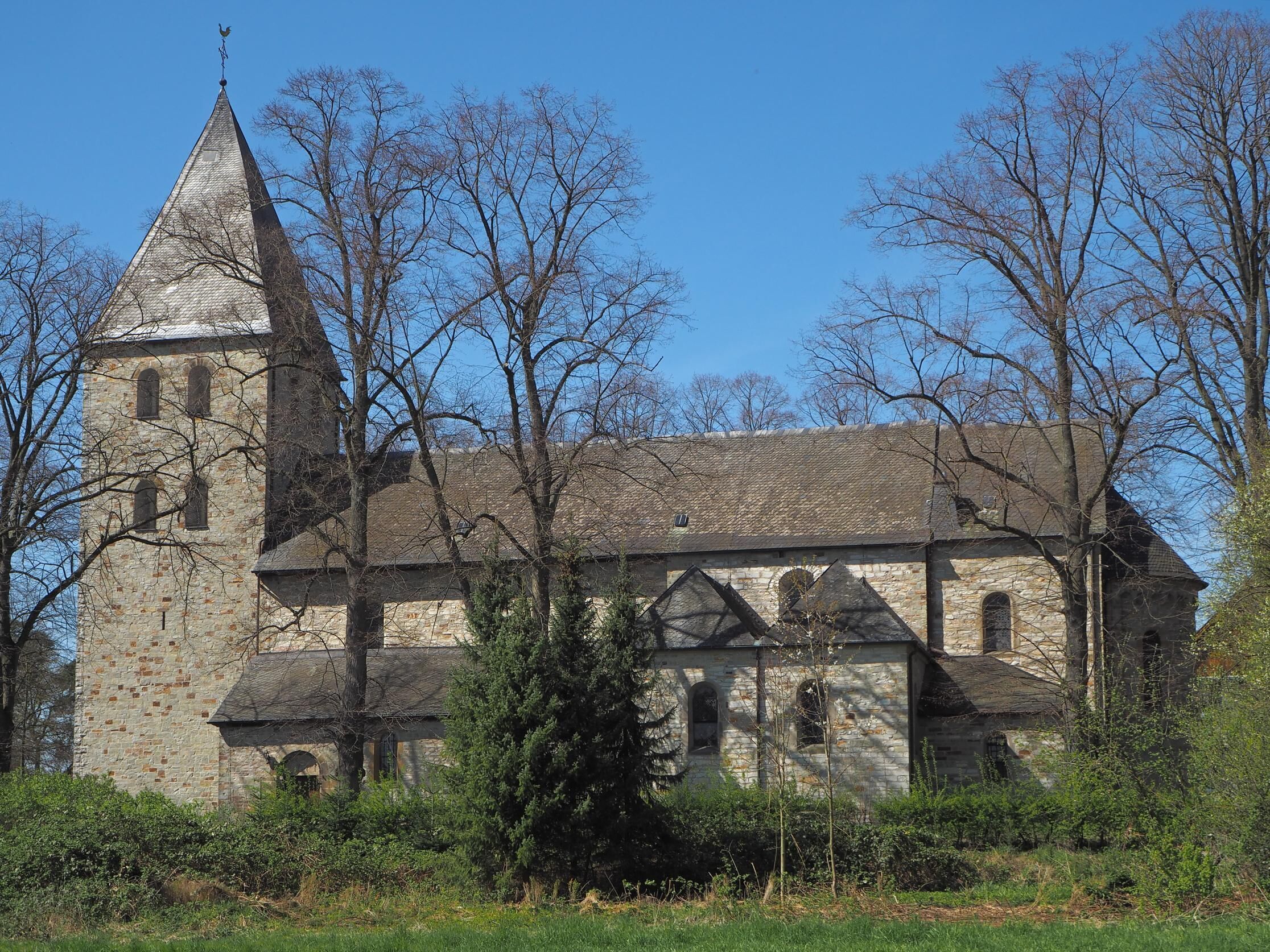 A historic stone church with a tall bell tower and arched windows.