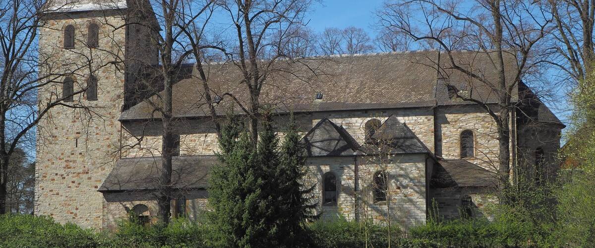 A historic stone church with a tall bell tower and arched windows.