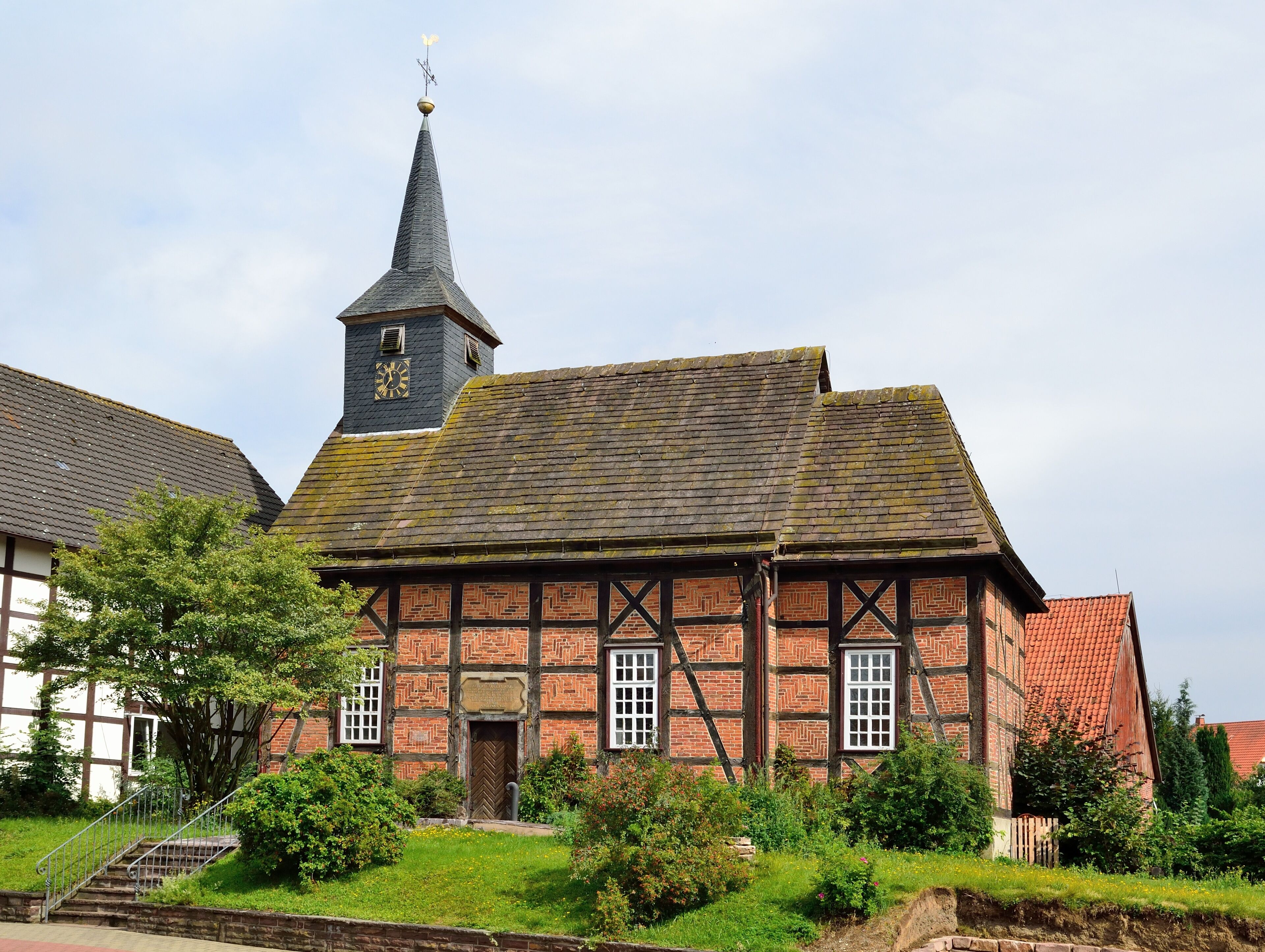 A half-timbered church with a clock tower and a steeply pitched roof.