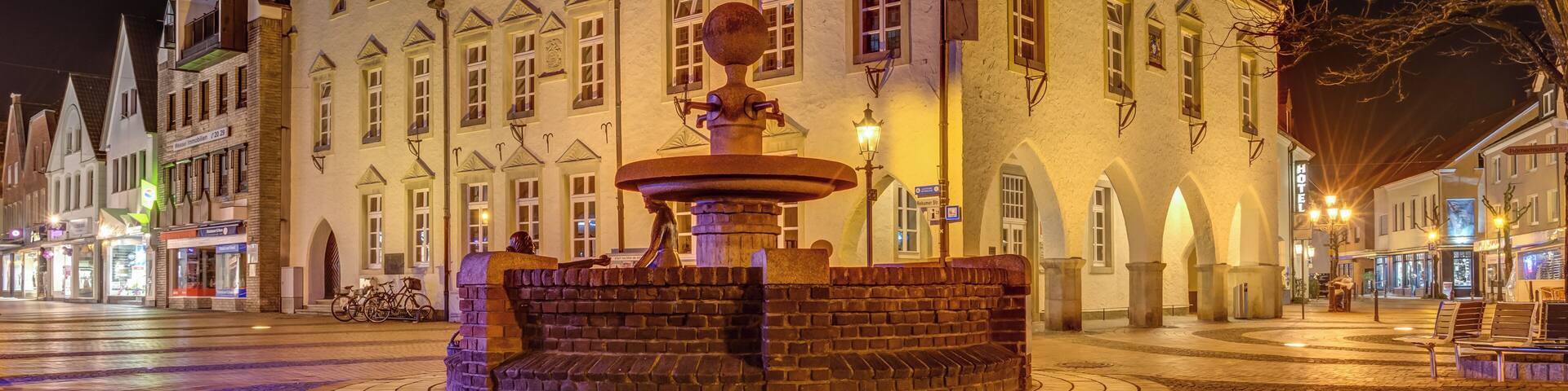 A historic building with a central fountain, surrounded by cobblestone streets and traditional architecture.