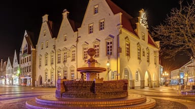 Un edificio histórico con una fuente central, rodeado de calles adoquinadas y arquitectura tradicional.