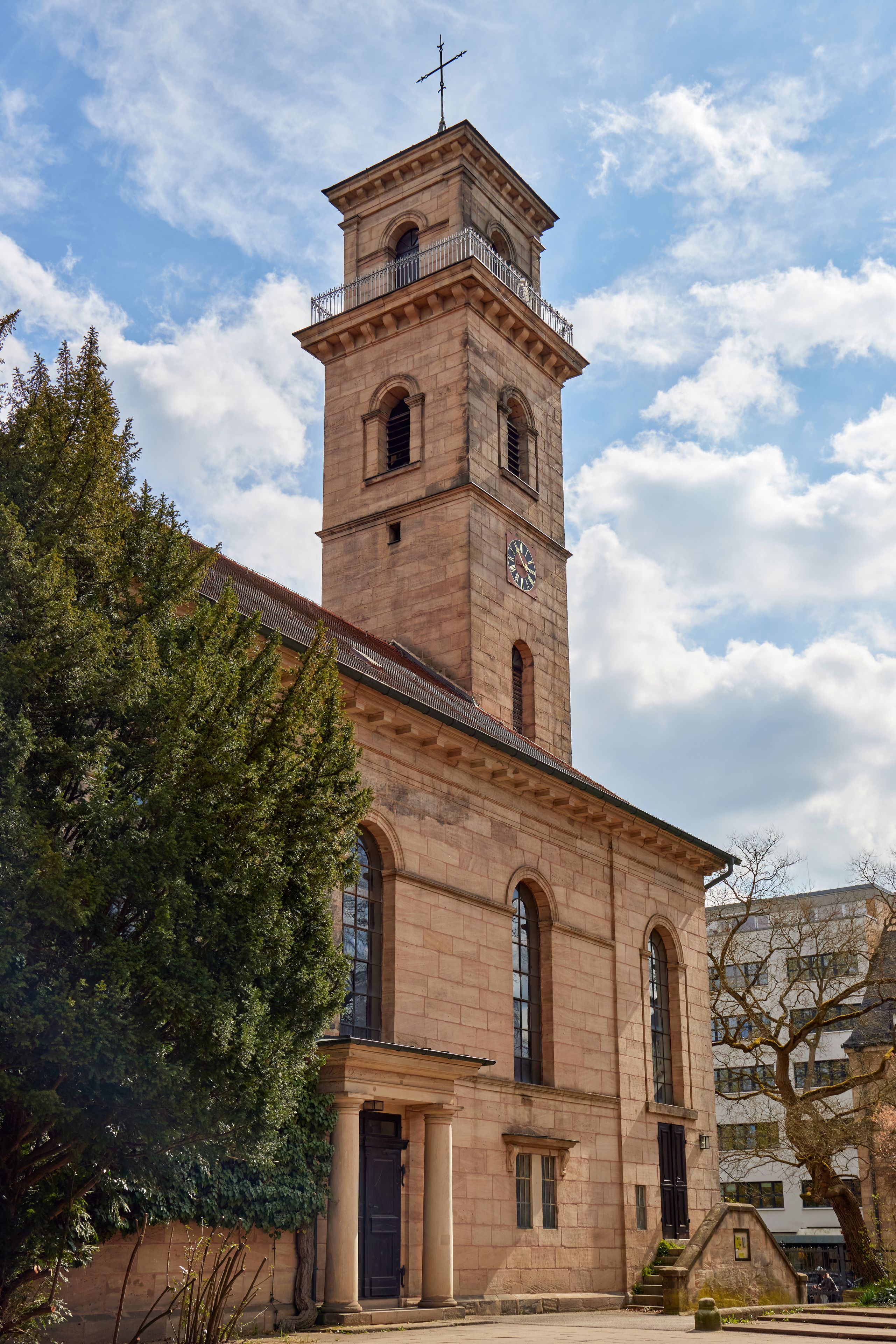 A historic church with a bell tower, large arched windows, and a clock.
