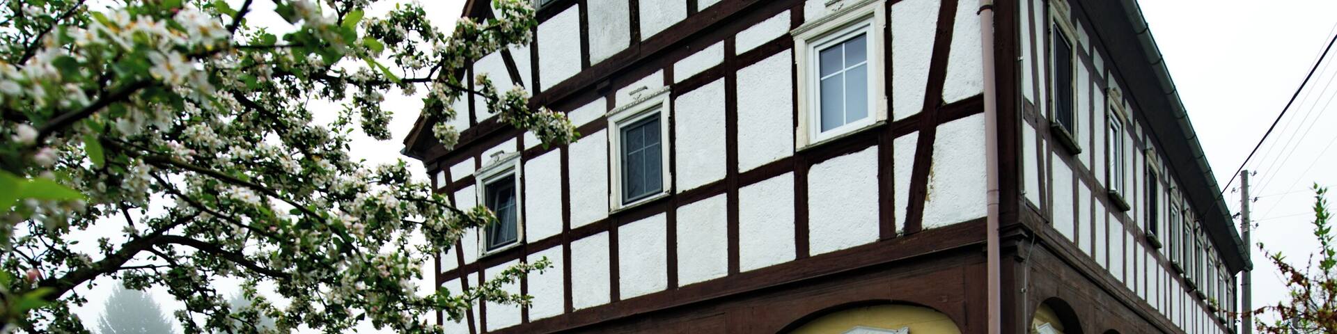 A traditional half-timbered house with a garden in front.