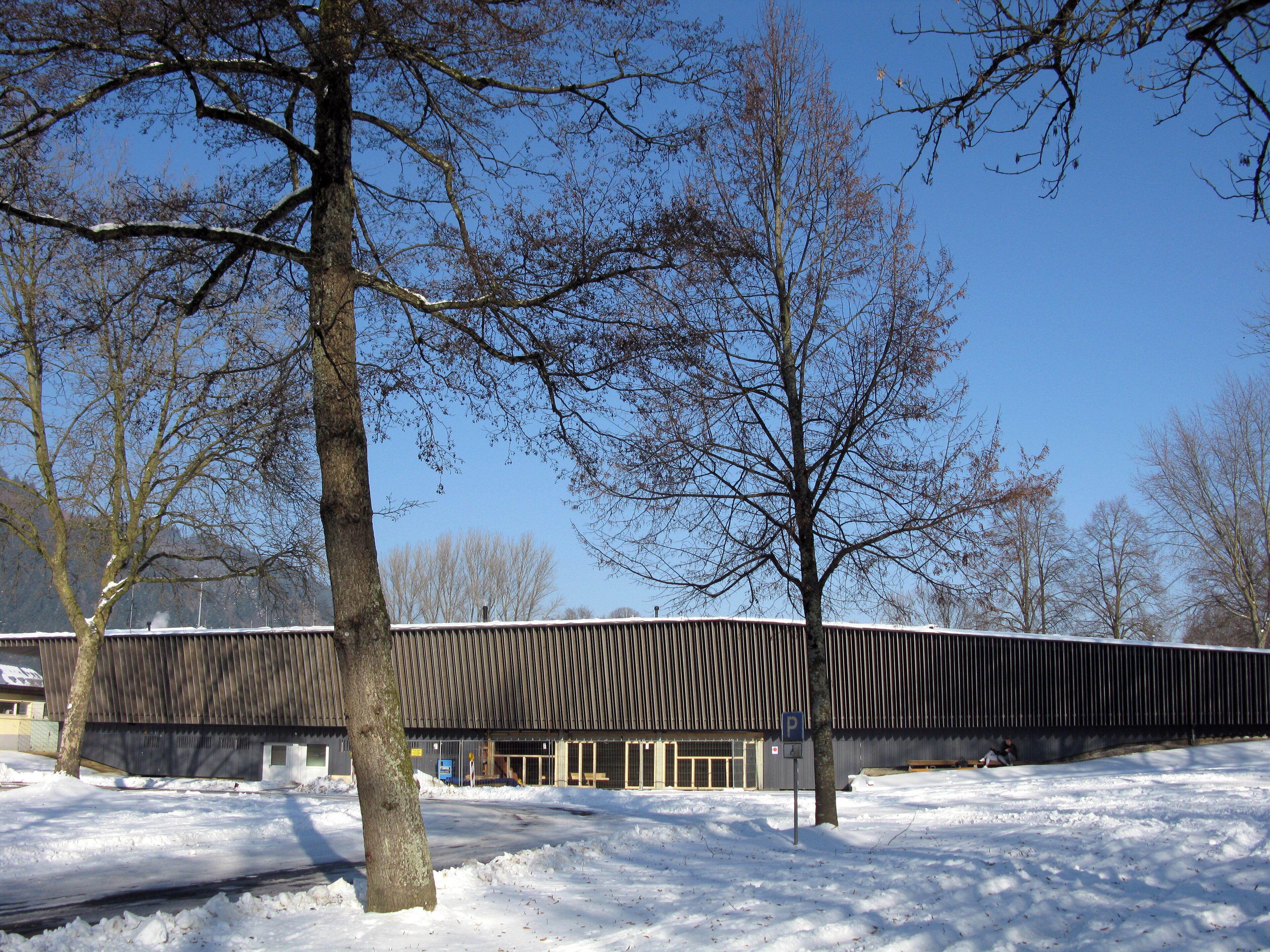 A snow-covered parking lot with a building in the background.